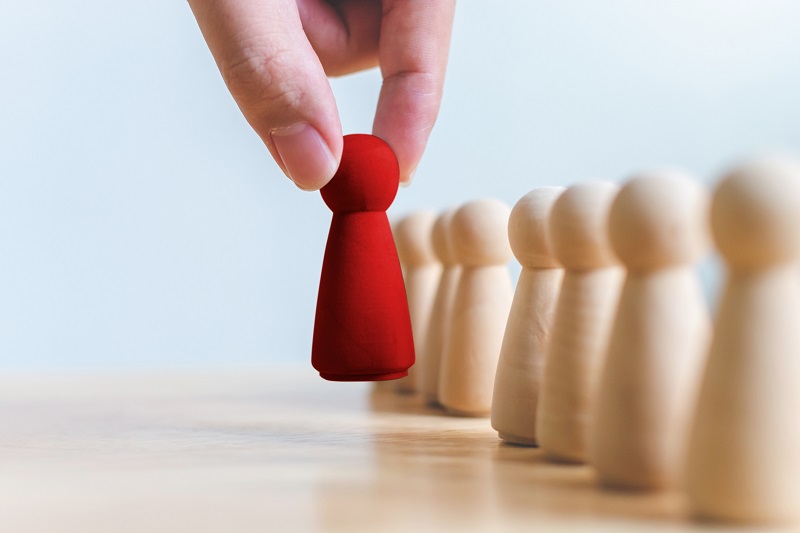 A hand placing a red-colored piece on a board.