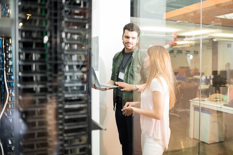 Ein Kollege und eine Kollegin überprüfen einen Datenserver.