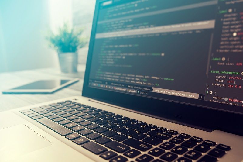 Ein Laptop, auf dem HTML-Code einer Datei im Dokument-Dateityp HTML angezeigt wird.