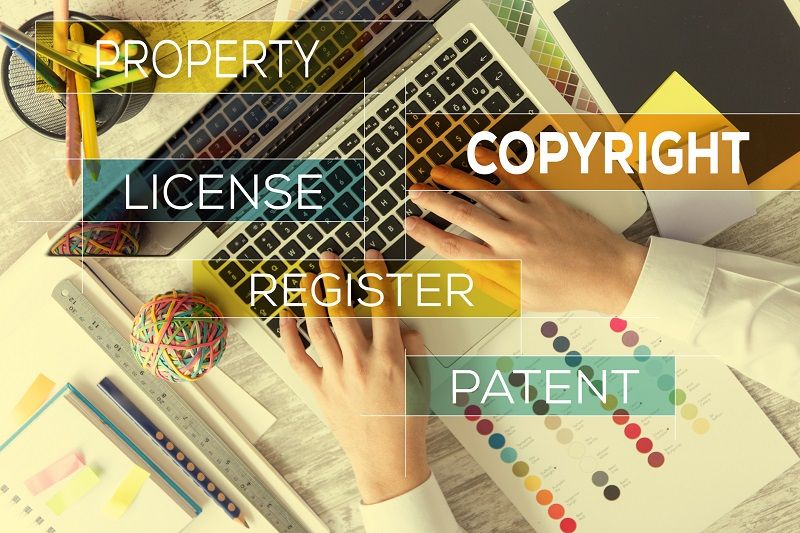 Ein Laptop, über dem verschiedene Wörter abgebildet sind, die zum Thema Bildcopyright gehören.