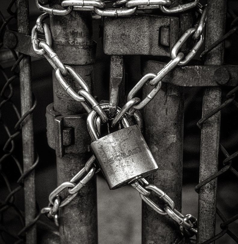 A padlock chaining a gate.