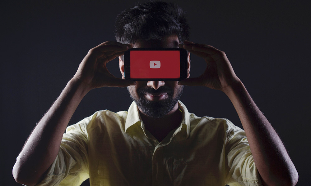 A man holding a smartphone to his eyes.